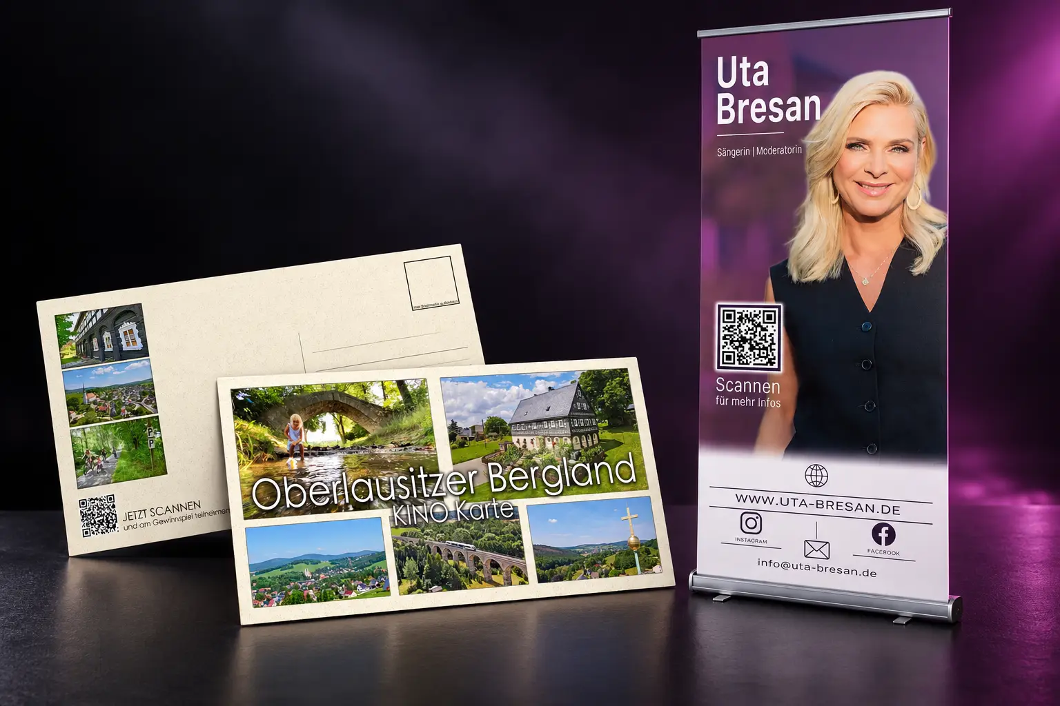 Produktvisualisierung: Roll-up für Uta Bresan und Postkarten für das Oberlausitzer Bergland, vor schwarzem Hintergrund mit violettem Licht.